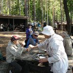 Kesällä retkipöydän ääressä on ihmisiä